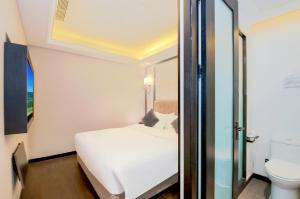 a bedroom with a white bed and a toilet at WangfujingXiyuanHotel Central Beijing in Beijing