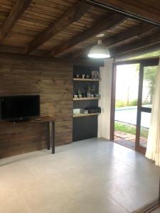a living room with a flat screen tv and a wooden wall at Casa rústica in Torres