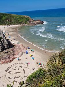 a beach with people and umbrellas and the ocean at Casa rústica in Torres