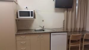 a small kitchen with a sink and a microwave at Injune Haven in Injune