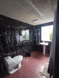ein Badezimmer mit Toilette und Waschbecken in der Unterkunft Mate Sur Hostal in Cochrane