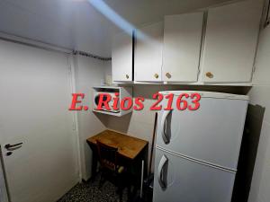 a small kitchen with a refrigerator and a table at Dos ambientes plaza colon in Mar del Plata