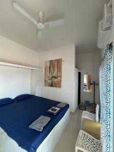 a bedroom with a blue bed and a white ceiling at Sandbox in Malvan +7 photos