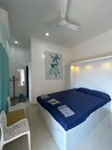 a large blue bed in a room with a chair at Sandbox in Malvan