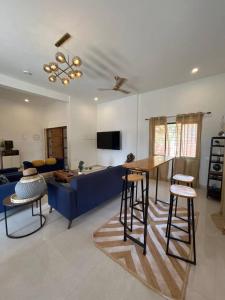 a living room with a blue couch and a table at Sandbox in Malvan