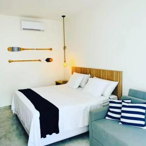 a bedroom with a white bed and a blue couch at Meditarranee Residence in Camocim