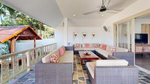 a patio with a couch and chairs and a table at Idyllic Samui Beach Villa Resort in Choeng Mon Beach