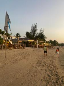two people standing on a beach flying a kite at Meditarranee Residence in Camocim