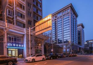 a city street with cars parked in front of tall buildings at WangfujingXiyuanHotel Central Beijing in Beijing