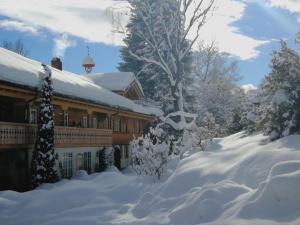 ein schneebedecktes Haus mit schneebedeckten Bäumen in der Unterkunft Das Talgut in Ofterschwang
