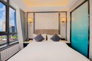 a bedroom with a large white bed and a window at WangfujingXiyuanHotel Central Beijing in Beijing