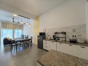 a kitchen and living room with a table and chairs at Langkawi Simfoni Lavanya Suite 13 in Kuah