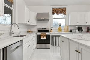 a white kitchen with a sink and a stove at The Palace in Rockford