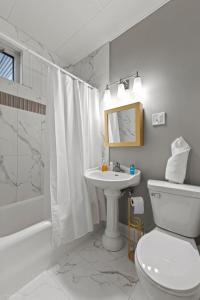 a white bathroom with a toilet and a sink at The Palace in Rockford +13 photos