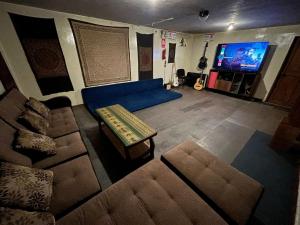 ein Wohnzimmer mit einer blauen Couch und einem Fernseher in der Unterkunft Intihuatana Hostel in Pisac