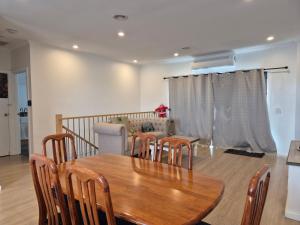 een eetkamer met een houten tafel en stoelen bij Sredna Homestay in Braybrook