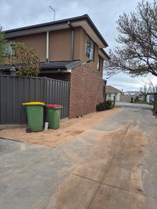 een huis met twee vuilnisbakken voor een oprit bij Sredna Homestay in Braybrook +6 foto's