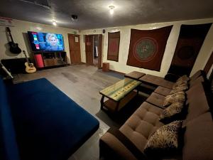 ein Wohnzimmer mit Sofa und Fernseher in der Unterkunft Intihuatana Hostel in Pisac