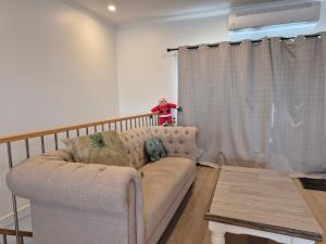 een woonkamer met een bank en een gordijn bij Sredna Homestay in Braybrook