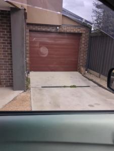 a garage with a brown garage door in a house at Sredna Homestay in Braybrook +5 photos