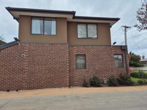 een rood bakstenen huis met twee ramen erop bij Sredna Homestay in Braybrook