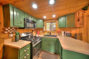 a kitchen with green cabinets and a stove at Cabin - Full Kitchen - pet friendly - TV in South Lake Tahoe