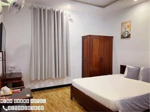 a bedroom with a bed and a cabinet and a window at Khách sạn Minh Quang in Phan Rang