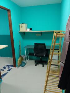 una camera da letto con una parete blu, una scrivania e una sedia di BP family room 4 a Ko Mak