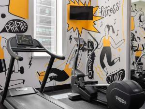 una palestra con un murale raffigurante una donna su un tapis roulant di ibis Dubai One Central a Dubai