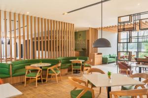 a restaurant with green furniture and tables and chairs at Park Inn & Suites by Radisson, Puri in Puri