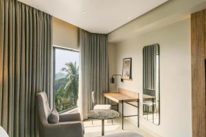 a hotel room with a desk and a window at Park Inn & Suites by Radisson, Puri in Puri