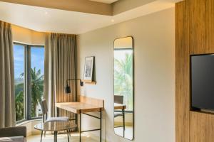 a hotel room with a desk and a large window at Park Inn & Suites by Radisson, Puri in Puri