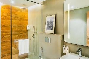 a bathroom with a shower and a sink and a mirror at Park Inn & Suites by Radisson, Puri in Puri +14 photos