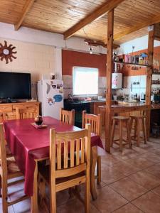 a kitchen with a table and chairs and a refrigerator at Cabaña La Anita in Cosquín