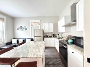a kitchen with white cabinets and a marble counter top at Carytown nest King Bed fully fenced in Richmond