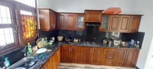 a kitchen with wooden cabinets and a sink at Negombo Villa in Negombo