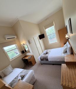 una camera con due letti e un divano e due finestre di Campbell st Lodge a Castlemaine