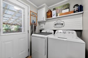 a white laundry room with a washer and dryer at Twin Ponds Retreats retreat in Whittier