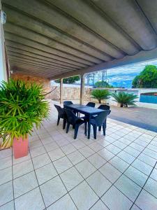 a table and chairs on a patio with a view of the ocean at Casa na Vila ivonete in Rio Branco