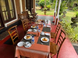 a table with plates of food on a porch at Westrom Villa Ocean Front in Bentota