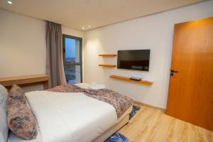a bedroom with a bed and a flat screen tv at Great Holiday suites in Agadir