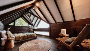 a bedroom with a bed and a large window at Wanagiri Cabin Wanara in Gitgit