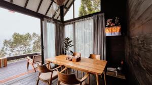 a dining room with a wooden table and chairs at Wanagiri Cabin Wanara in Gitgit