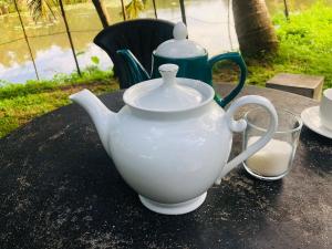 a white tea pot sitting on top of a table at Secret Garden Mirissa in Mirissa