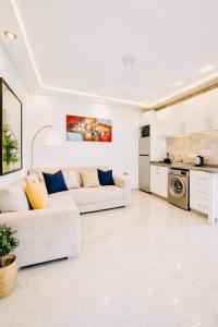 een witte woonkamer met een bank en een keuken bij Luxury Villa with Pool & Garden5km from Cabo in Tetouan