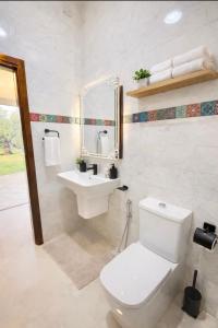 een witte badkamer met een toilet en een wastafel bij Luxury Villa with Pool & Garden5km from Cabo in Tetouan