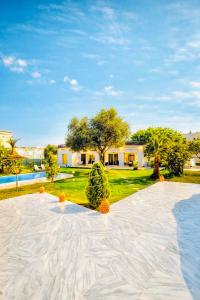 een grote tuin met een huis op de achtergrond bij Luxury Villa with Pool & Garden5km from Cabo in Tetouan +15 foto's