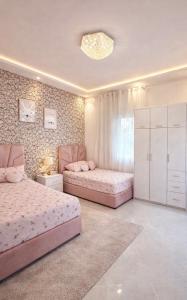 twee bedden in een slaapkamer met roze meubels bij Luxury Villa with Pool & Garden5km from Cabo in Tetouan