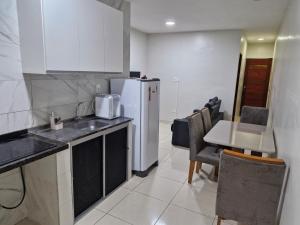 a kitchen with a white refrigerator and a table at Próximo a roda gigante in Maceió
