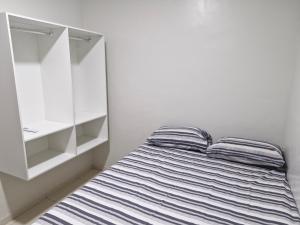 a bedroom with a bed and a white cabinet at Próximo a roda gigante in Maceió